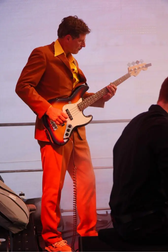 Bassist der Freisein Funk Unit im orangefarbenen Anzug auf der Bühne