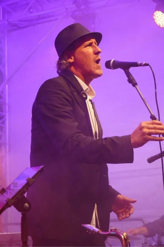 Weert singt mit Hut im violetten Licht
