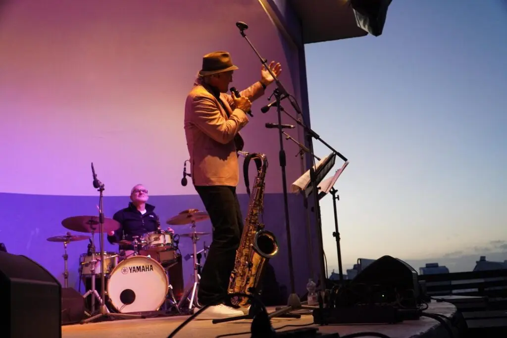Weert singt vor dem Schlagzeug im Abendlicht, Freisein Funk Unit live