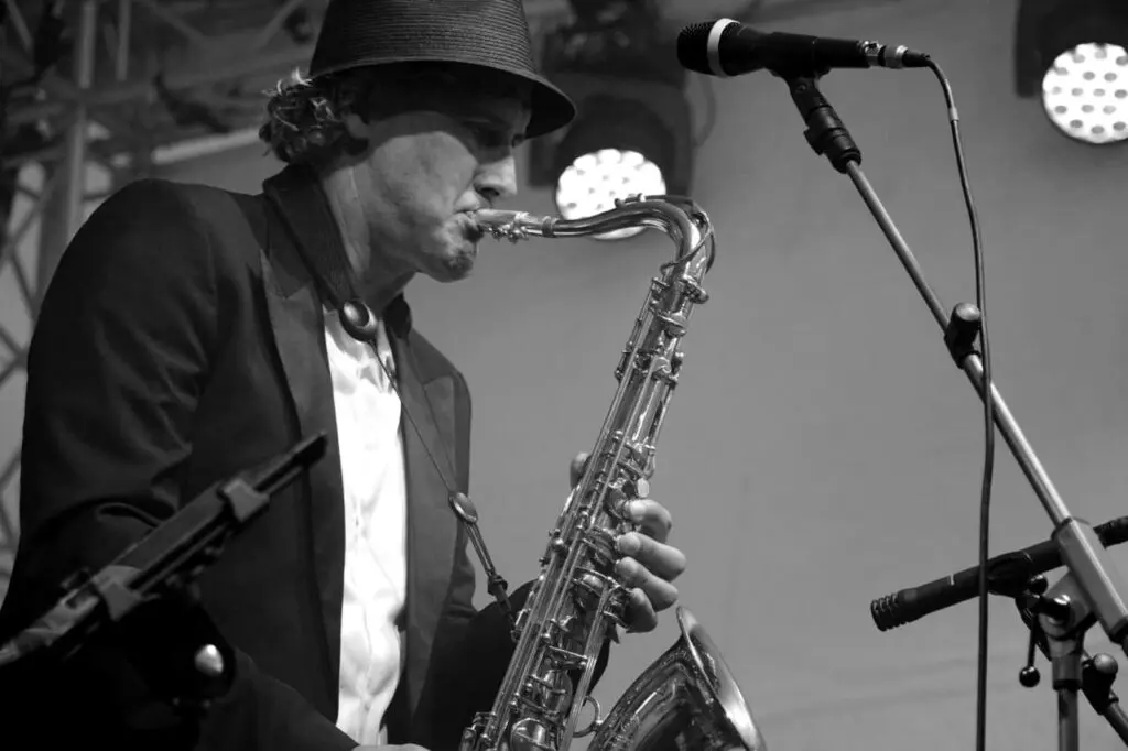 Schwarz-Weiß-Foto: Weert mit Hut spielt Tenorsaxophon live auf der Bühne